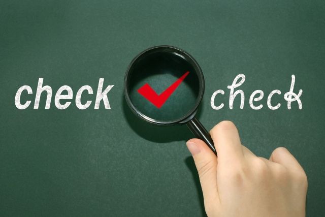 黒板に書かれたcheckを覗く虫眼鏡